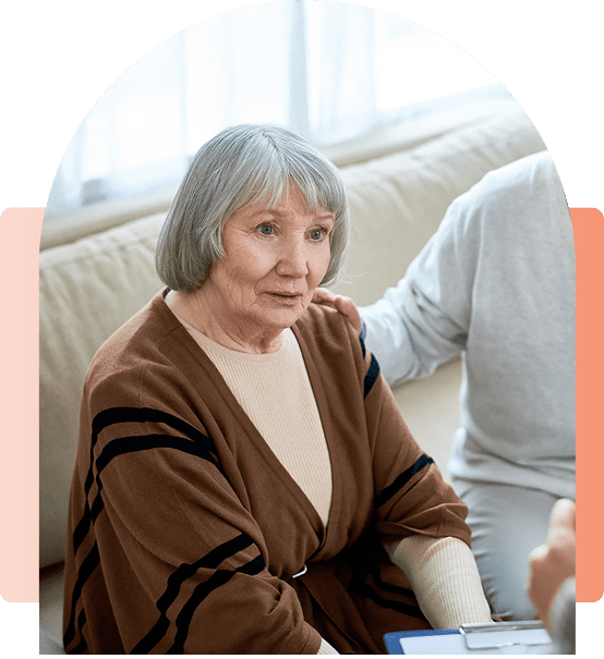 Elderly woman receiving comforting support at home.